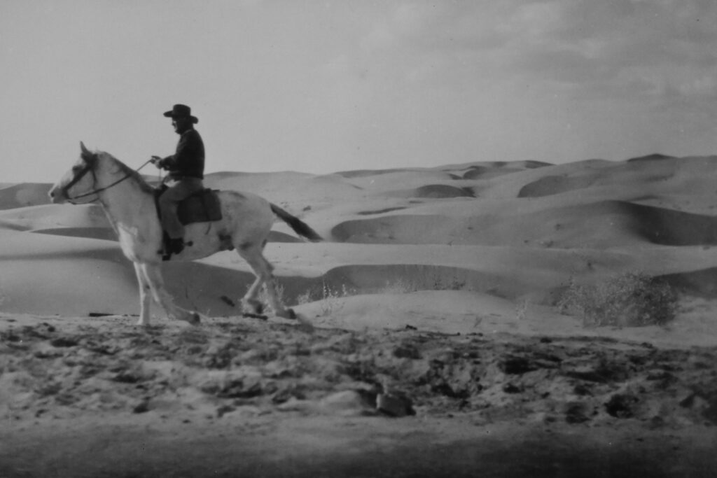 Vintage, black and white. Cowboy on horseback in desert